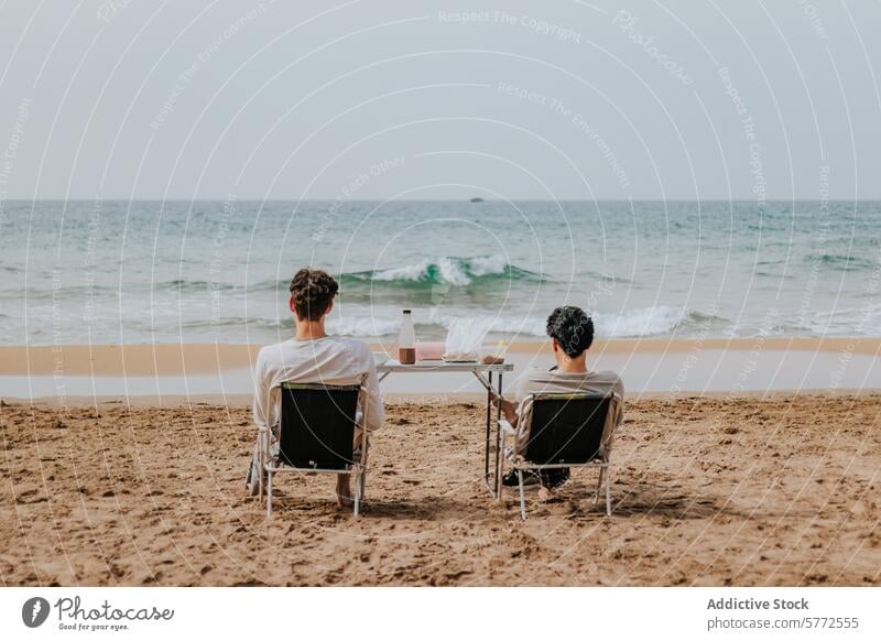 Ein Paar genießt einen ruhigen Tag am Strand Meer Sitzen Stühle Sand Erholung Ufer Seeküste Wein Brille Tisch friedlich Horizont Gelassenheit Freizeit Urlaub