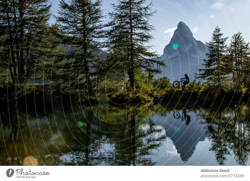 Silhouettenbiken am ruhigen Matterhornseeufer Person Fahrrad See Reflexion & Spiegelung Wasser Berge u. Gebirge Bäume Windstille Gelassenheit Blauer Himmel