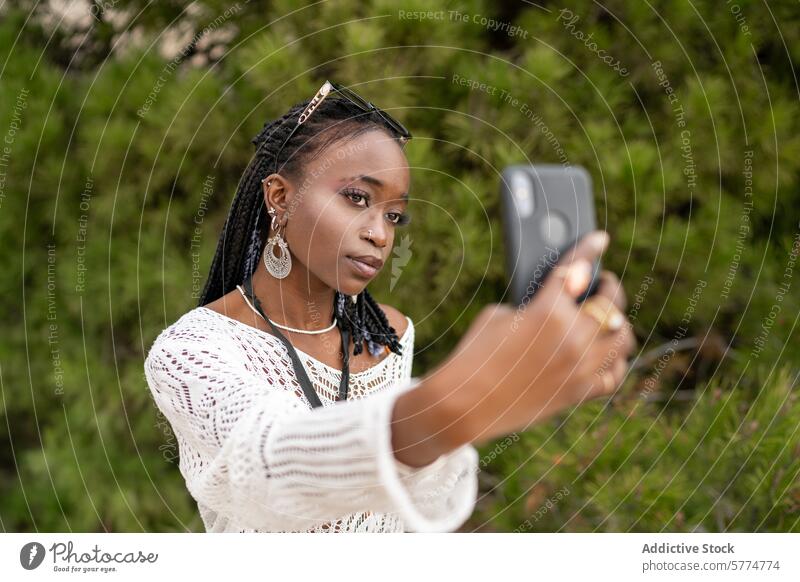 Junges schwarzes Mädchen, das ein Selfie im Freien macht Smartphone Grün ethnisch Schmuck jung Schwingung sorgenfrei Afroamerikaner lässig Stil Mode Freizeit