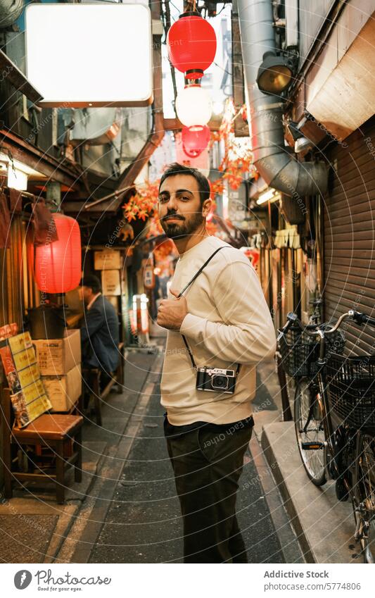 Mann mit Kamera wandert durch eine mit japanischen Laternen gesäumte Gasse Reisender Fotokamera Japan rot traditionell Erkundung Kultur Sightseeing Tourismus
