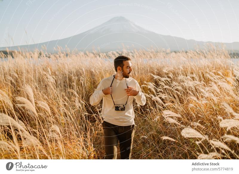 Japan erkunden, Mann mit Kamera vor dem Berg Fuji Reisender Fuji Berg Fotokamera Erkundung majestätisch Ansicht Pampasgras Klarer Himmel Abenteuer Tourist Natur