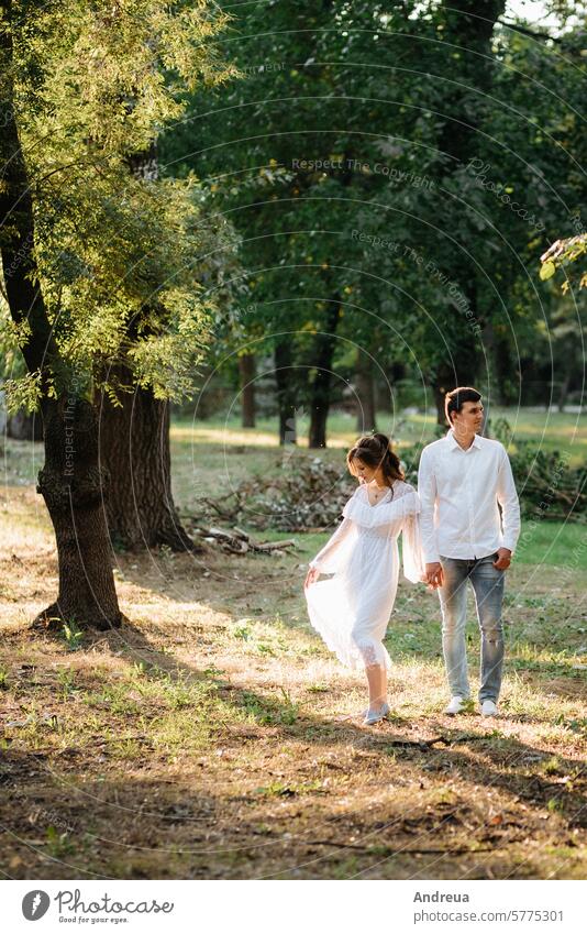 Ein Mann und ein Mädchen gehen in einem Waldpark spazieren Typ Spaziergang Zusammensein Park grün braun Liebesgeschichte Tag Sommer Frühling