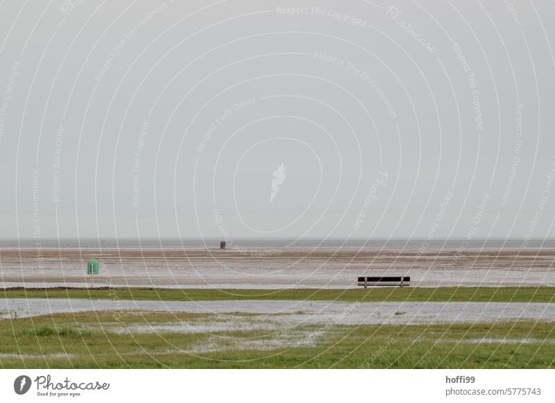 minimalistische Szene an der Nordsee mit Bank, Mülleimer und überschwemmter Liegewiese Nordseeküste Meer Küste Sitzbank Überschwemmung schlechtes Wetter Flut