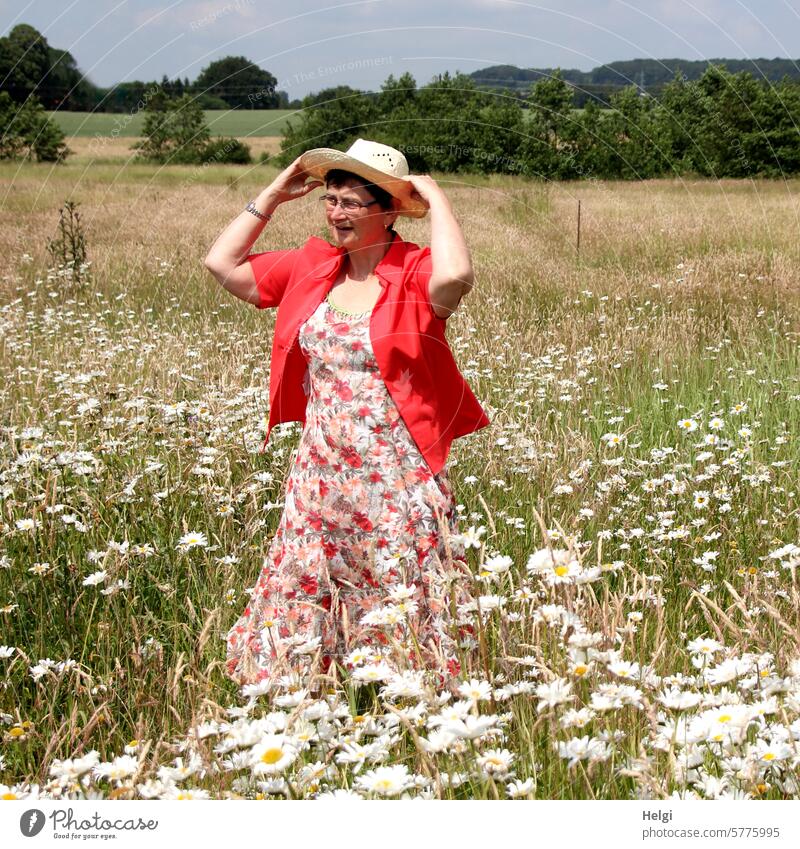 sommerlich gekleidete Frau steht in einer Blumenwiese Mensch weiblich Erwachsene Kleid geblümt Bluse Sonnenhut Margariten Margaritenwiese Sommer Farbfoto