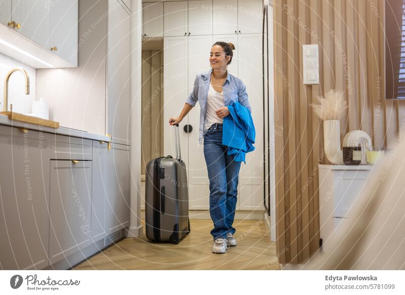 Junge Frau betritt Mietwohnung mit Gepäck Koffer Verpackung Bekleidung Ferien reisen Vorbereitung Menschen eine Person Tasche Tourismus Reisender Tourist