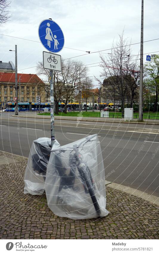Transparente Folie als Regenschutz über einem E-Bike auf dem Bürgersteig mit Kopfsteinpflaster in der Goethestraße in Leipzig im Freistaat Sachsen Rad Fahrrad