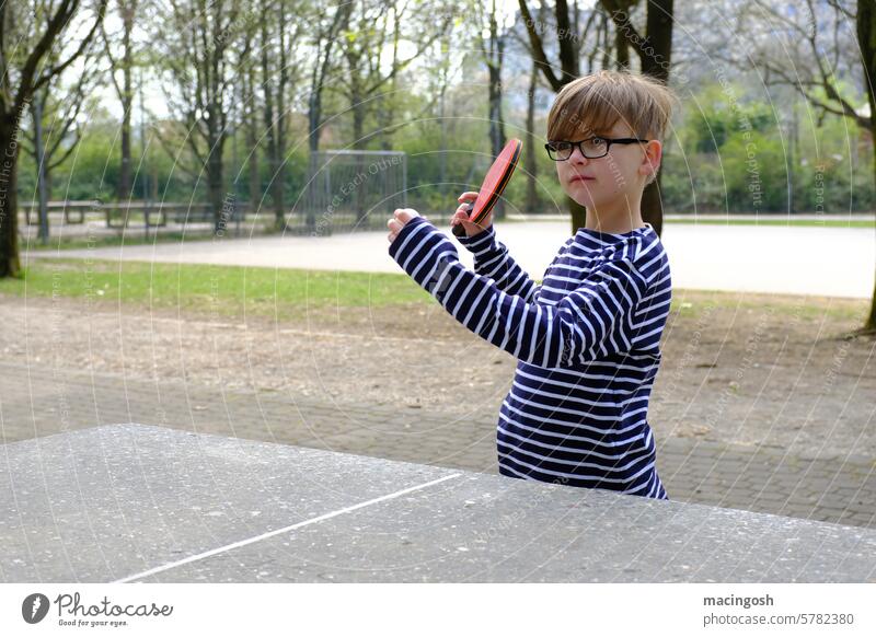 Kleiner Junge spielt Tischtennis im Park Tischtennisschläger Tischtennisplatte Pingpong Ping-Pong Freizeit & Hobby Sport Kind Kindheit Ballsport Spielen