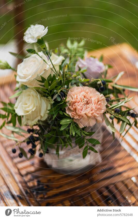 Eleganter Hochzeitsschmuck auf einem Holztisch Kernstück Blume Roséwein rosa weiß grün Laubwerk Tisch hölzern rustikal romantisch hochzeitlich