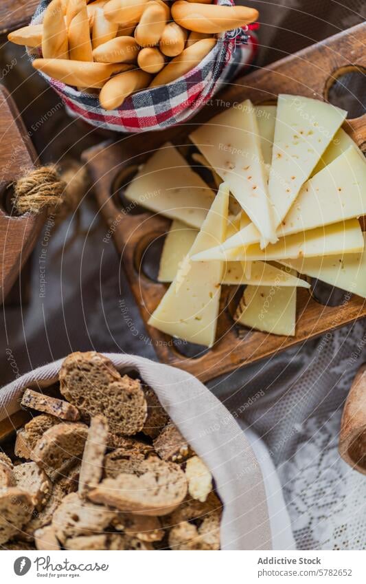 Handwerkskäse und Brotstangen auf Holzbrett Käse biscotti hölzern Servieren Tablett rustikal Feinschmecker Scheibe knusprig Aufstrich Kunstgewerbler
