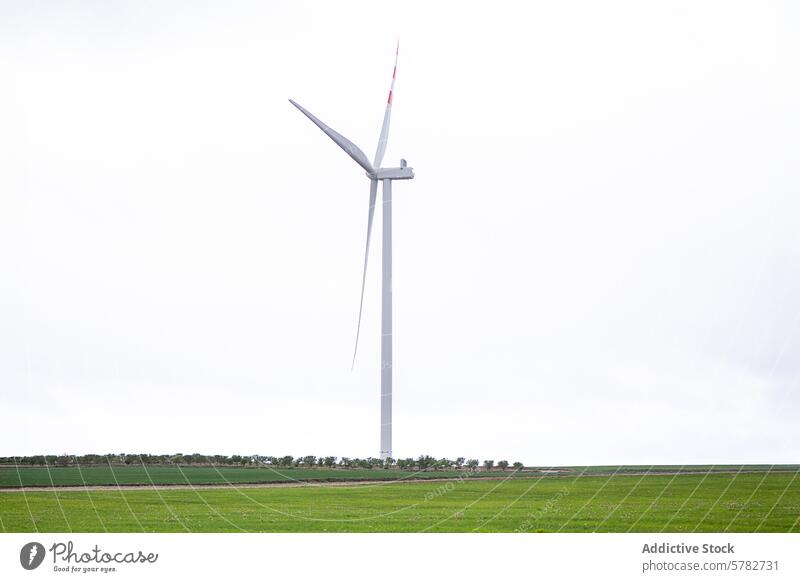 Eine einsame Windkraftanlage auf einer weiten grünen Wiese Feld wolkig Himmel alternativ Energie Single riesig Landschaft Umwelt nachhaltig