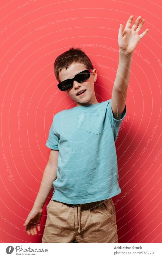 Cooler Junge posiert mit Sonnenbrille auf rosa Hintergrund Kind cool spielerisch jung Pose Mode Stil pulsierend lässig T-Shirt Shorts Spaß heiter Jugend modern