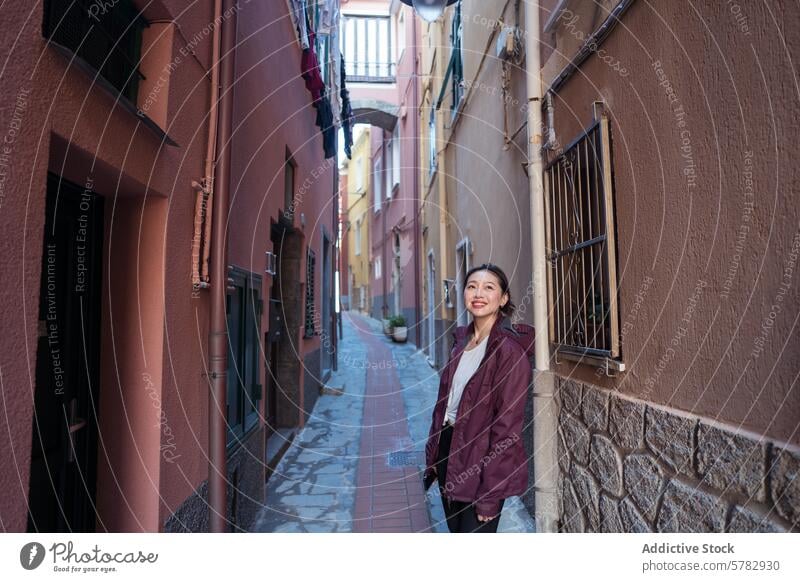 Tourist genießt eine malerische italienische Gasse Frau Reisender Italien charmant Dorf eng Gebäude farbenfroh Architektur Lächeln asiatisch erkundend urig
