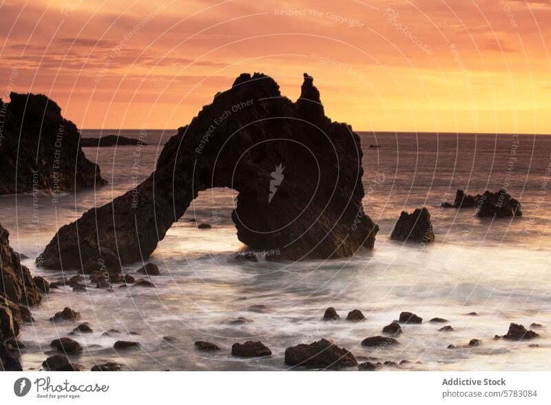 Sonnenuntergang am Playa de los Roques mit natürlichem Felsbogen dramatisch Gesteinsformationen Hintergrund sanft Wasser Oberfläche Langzeitbelichtung Abend