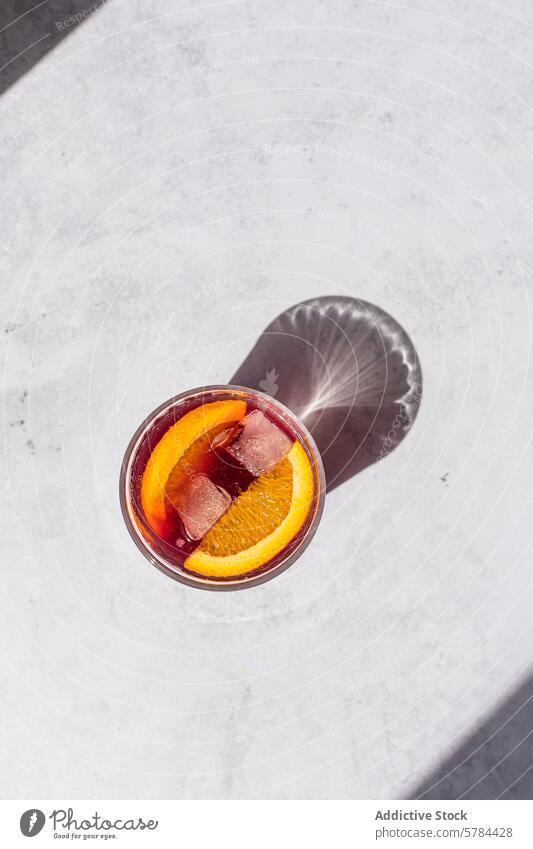 Erfrischender Tinto de Verano Cocktail mit Orangenscheibe Verandawein Spanisch trinken Getränk Erfrischung Eis Sommer kalt Glas Luftaufnahme helle Oberfläche