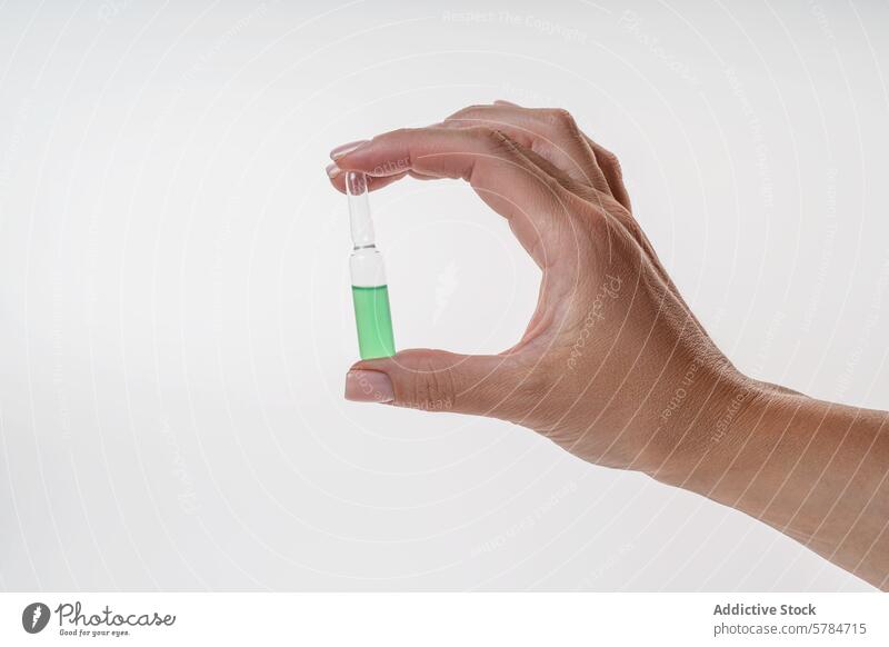 Hand mit grünem Aloe-Extrakt-Serum in einem Tropfer anzapfen Hautpflege Wellness Frau Nahaufnahme weißer Hintergrund Eleganz Schönheit Pflege Produkt