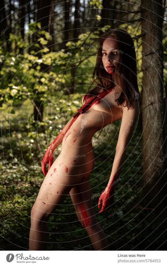 Eine wunderschöne und blutige brünette Frau streift durch die wilden Wälder. Sie ist selbst ganz wild und fühlt sich frei in ihrer Haut. Ein nacktes Mädchen hat einige Vampir-Vibes am Laufen. Oder vielleicht der Teufel.