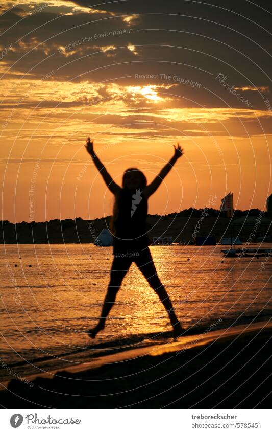X Silhouette eines springenden Kindes am Strand jung x Formular Sonne Spaß Sport Fitness schwarz Schatten Licht Abend Sonnenuntergang Meer Wasser hell glänzend