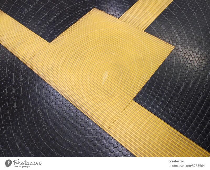 Gelbe Markierung auf schwarzem Noppenboden gelb Detailaufnahme u-bahnhof innen Boden Kontrast menschenleer Nahaufnahme streifen