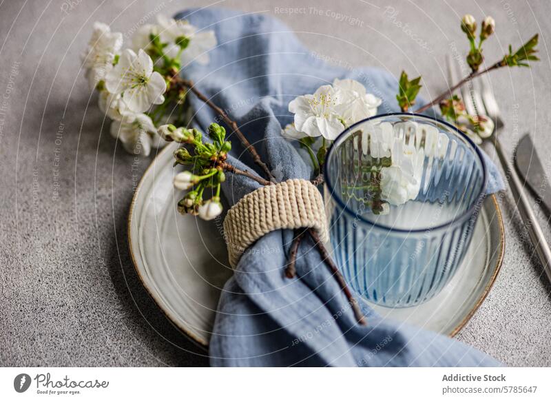 Elegant gedeckter Frühlingstisch mit Kirschblüten Tisch Ast Teller Glas gestreift Serviette Ring rustikal Textur Hintergrund Einstellung Dekor Eleganz