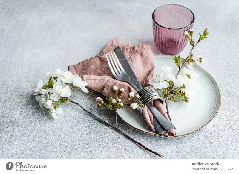 Elegante Tischdekoration zum Thema Kirschblüte im Frühling Tabelleneinstellung Kirschblüten Frühlingsthema elegant Besteck mauvefarbene Serviette Strukturglas