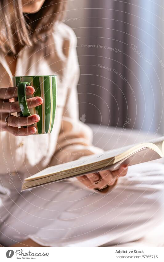 Anonyme entspannte Frau mit einem Buch und Kaffee am Morgen lesen Bett Erholung gemütlich warm trinken Freizeit Komfort friedlich Genuss Sitzen Lifestyle Hobby