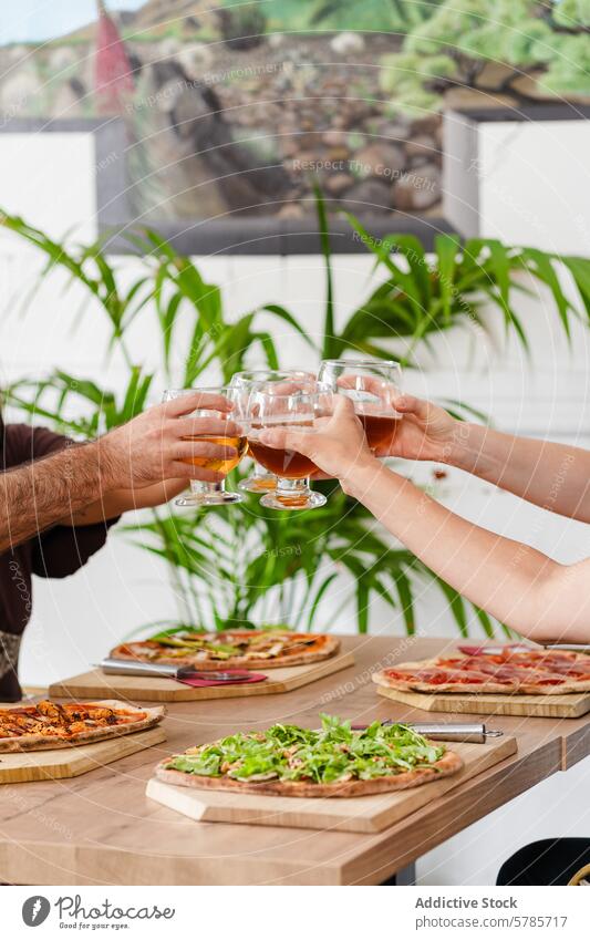 Anonyme Freunde stoßen mit glutenfreiem Bier bei Pizza an Röstung Feier Feinschmecker Beläge gutes Essen jubelt Sammeln sozial Party trinken handgefertigt