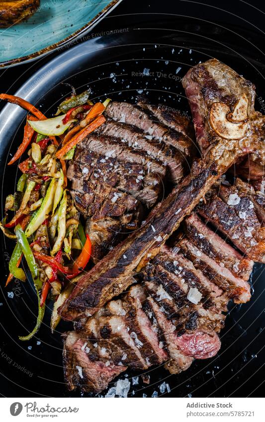 Perfekt gegartes T-Bone-Steak mit sautiertem Gemüse Rindfleisch T-Knochen gealtert 21-Tage gekocht Perfektion angebraten Salz Flocken verziert beschichtet