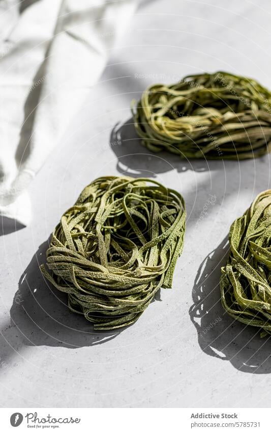 Frische grüne Nudelnester auf weißem Hintergrund Spätzle Nest roh Italienisch Küche Lebensmittel selbstgemacht Feinschmecker Gesundheit Spinat Mahlzeit