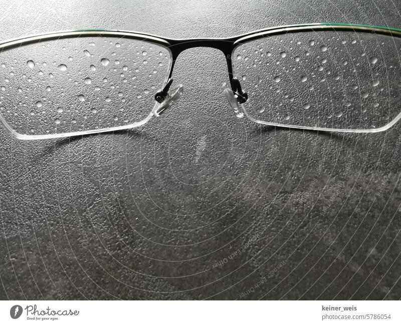 Die Brille ist nass nach der Tour durch den Regen Regentropfen Brillengläser Wassertropfen Gläser Nahaufnahme Tropfen Glas Regenwetter Wetter Regentag