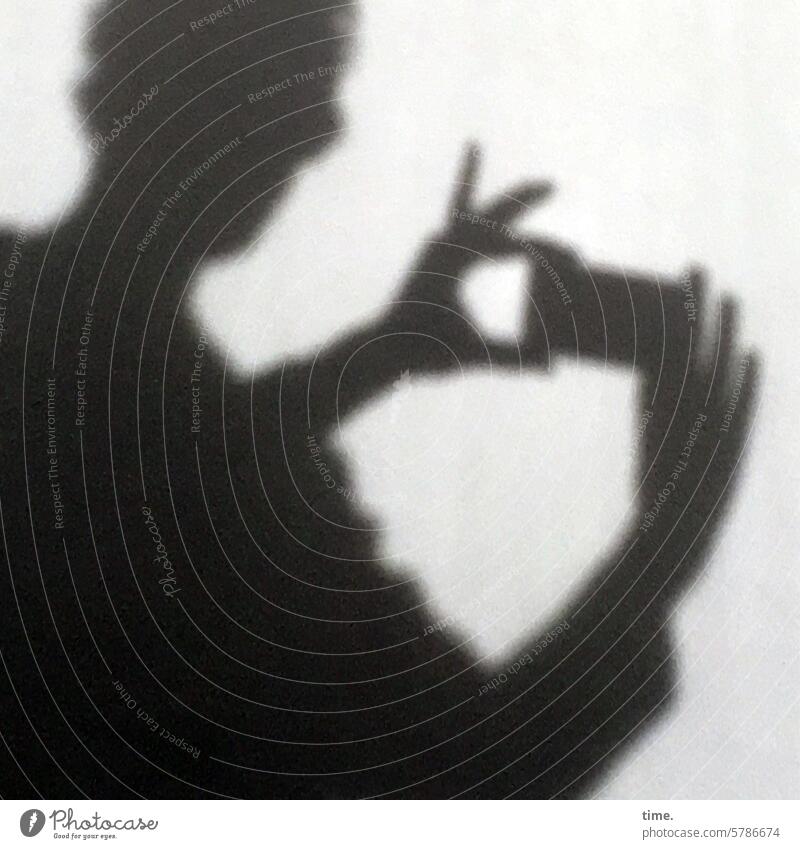 Standfinger und Spielfinger Mann Handy Silhouette Schatten sonnig Finger abgespreizt fokussieren fotografieren Beton Detailaufnahme filigran vorsichtig