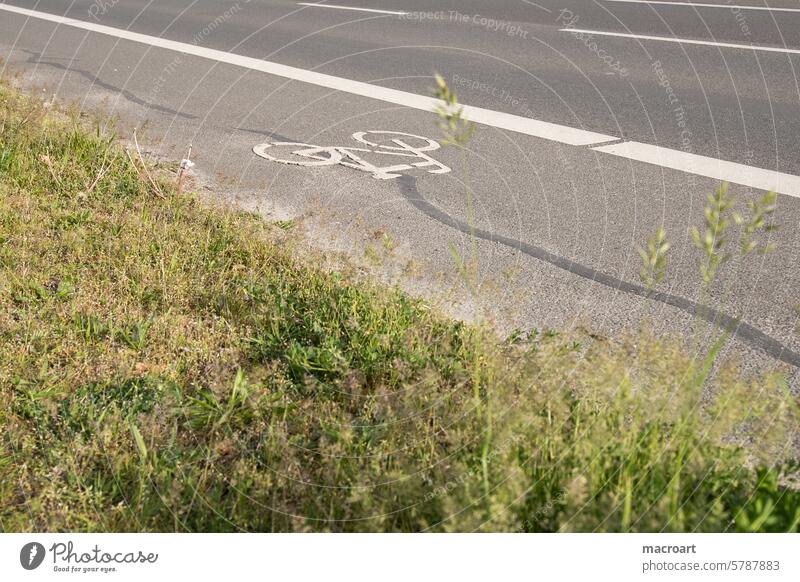 Fahrradweg mit Fahrradsymbol neben einer Straße Fahrradwege ökologisch grün fahrradwegbau fahrradsymbol energie nachhaltig verkehrsmittel streifen wiese begrünt
