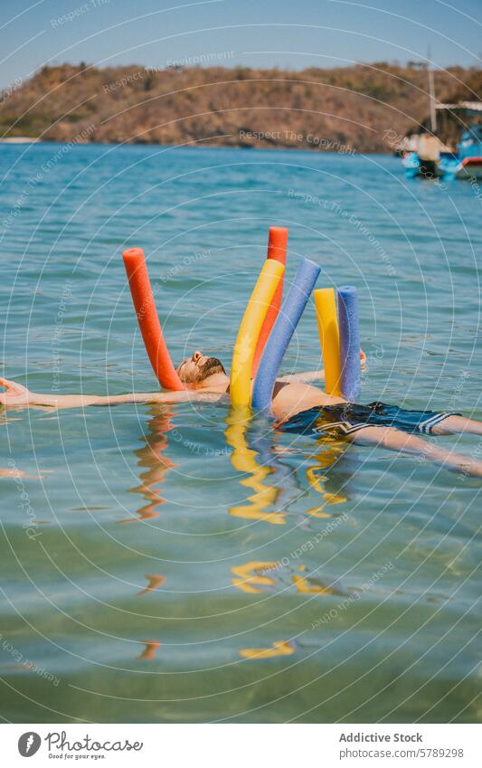 Entspanntes Schwimmen mit bunten Poolnudeln in den Gewässern Costa Ricas Wasser Schwimmer Erholung Schwimmsport blau farbenfroh MEER Windstille Freizeit Urlaub