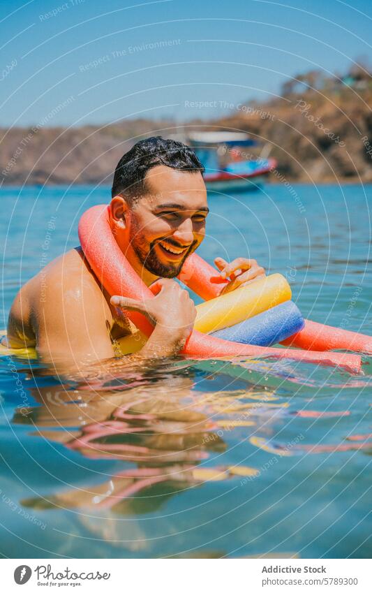 Mann genießt einen sonnigen Tag am Meer mit buntem Schwimmer MEER farbenfroh Nudel schwimmen Wasser Costa Rica Küstenlinie Glück Vollbart Urlaub fliegend