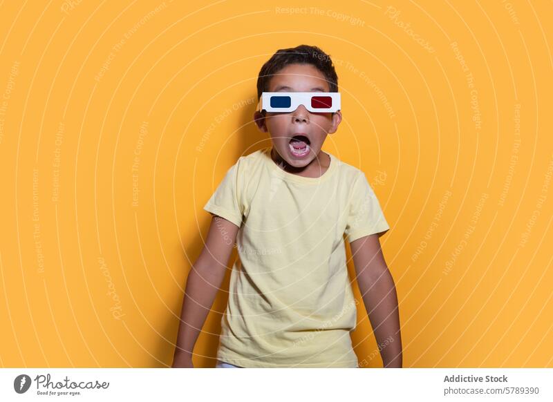 Aufgeregtes Kind mit 3D-Brille auf gelbem Hintergrund Atelier Staunen hell lässig Bekleidung Ausdruck Aufregung Spaß Entertainment Überraschung verblüfft jung