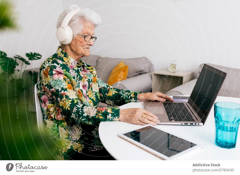 Ältere Frau macht sich die Technologie zunutze und arbeitet von zu Hause aus Senior Technik & Technologie Laptop arbeiten heimwärts Kopfhörer älter modern