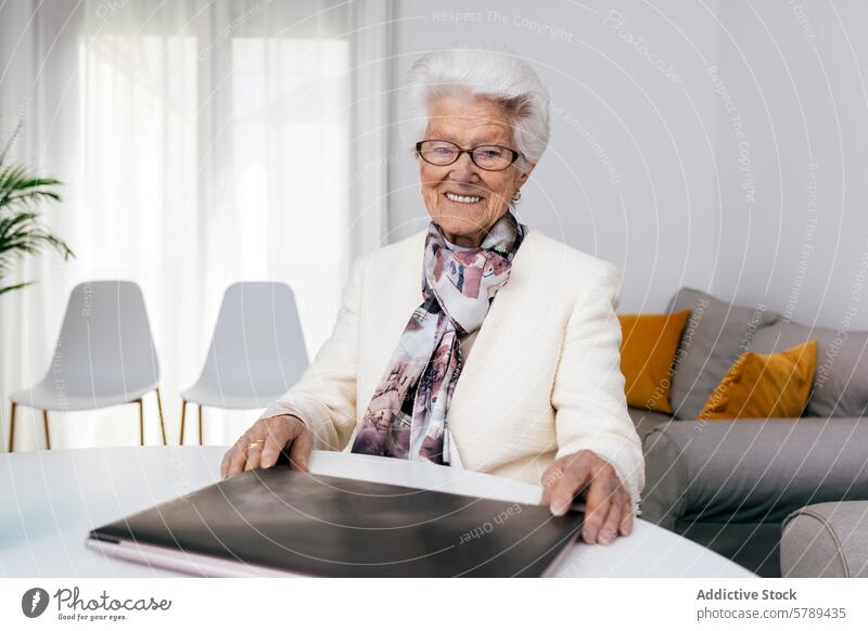 Ältere Frau mit Laptop zu Hause zeigt Freude an der Arbeit älter Senior heimwärts arbeiten heiter Lächeln im Innenbereich Technik & Technologie Benutzer
