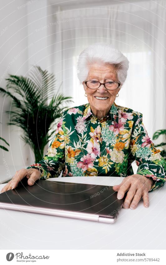 Ältere Frau lächelt bei der Arbeit mit dem Laptop zu Hause älter Senior arbeiten heimwärts Lächeln heiter aktiv gealtert Computer Technik & Technologie