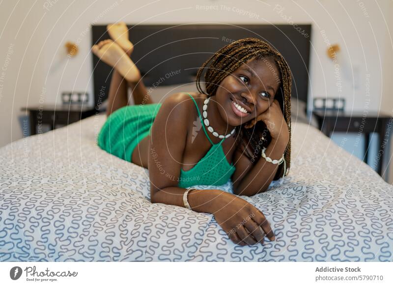 Entspannte afroamerikanische Frau genießt die Zeit zu Hause Afroamerikaner schwarz entspannt heimwärts Schlafzimmer Lügen Bett Glück Lächeln Freude lässig