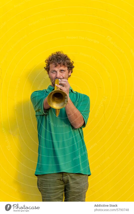 Einarmiger Trompeter, der gegen eine gelbe Wand spielt einarmig Mann Straßenkünstler Musik Leistung Musiker ein Arm Behinderung Spielen im Freien männlich Fokus