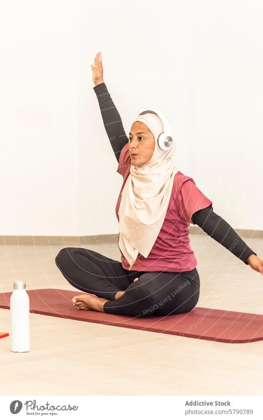 Muslimische Frau übt Yoga in bequemer Kleidung muslimisch Pose ardha matsyendrasana sitzend verdrehen Hijab Sportbekleidung Wellness Gesundheit Übung Ruhe