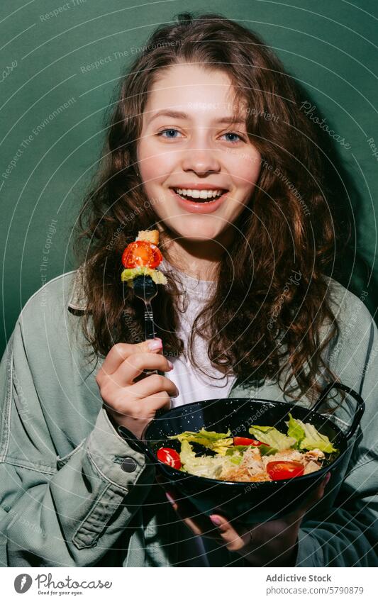 Junge Frau genießt einen frischen Caesar-Salat Salatbeilage Essen heiter Lächeln lässig speisend Biss Zutaten jugendlich Fröhlichkeit Genuss Schalen & Schüsseln