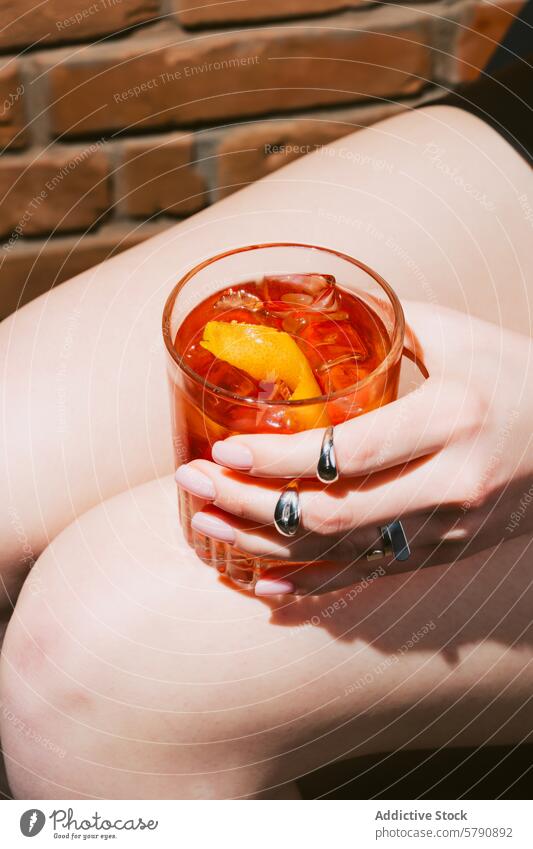 Nahaufnahme eines erfrischenden Negroni-Cocktails in der Hand negroni Glas Eis Orangenhaut Erfrischung Freizeit trinken Getränk Alkohol aktualisieren