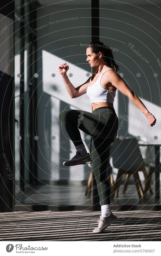 Sportliche Frau beim Üben im Haus mit moderner Kulisse Athlet Training heimwärts Fitness Gesundheit Lifestyle im Innenbereich Sportbekleidung trainiert. Stil