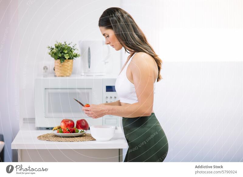 Sportliche Frau bei der Zubereitung einer gesunden Mahlzeit zu Hause sportlich Gesundheit Vorbereitung Küche heimwärts Fitness Sportkleidung Schneiden Gemüse