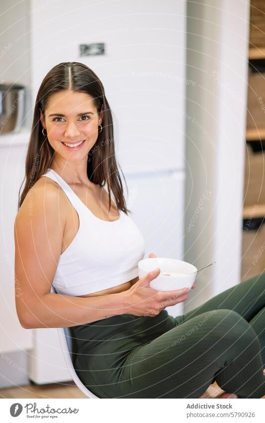 Lächelnde Fitness-Frau zu Hause beim gesunden Essen Gesundheit heimwärts Küche Sportbekleidung sportlich Mahlzeit heiter Schalen & Schüsseln Lifestyle
