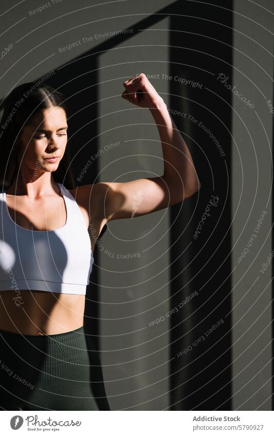 Sportliche Frau zeigt ihre Muskeln zu Hause sportlich Fitness heimwärts Stärke Gesundheit Training Bizeps flex Sportbekleidung aktiv Lifestyle Wohlbefinden