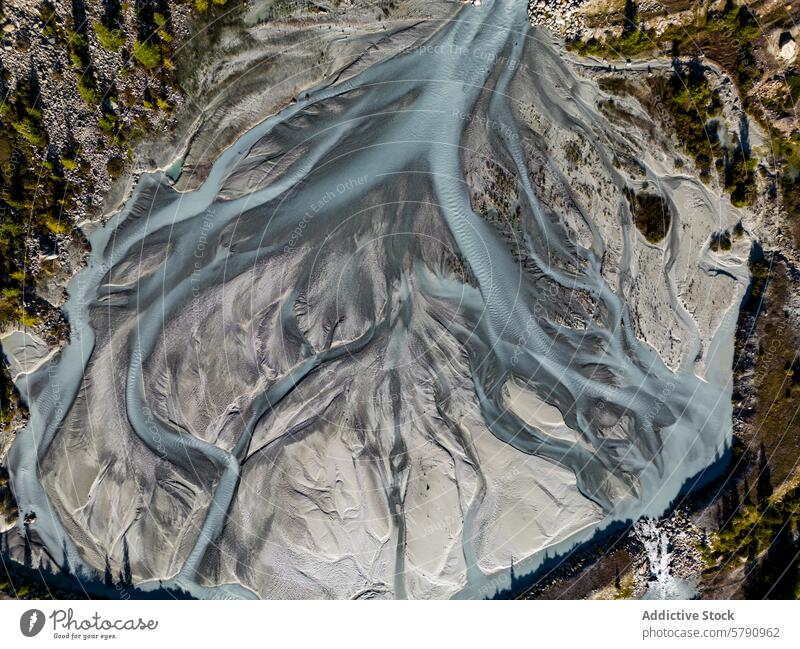 Das Luftbild zeigt die komplizierten Muster eines verzweigten Flusssystems, das von zerklüftetem Gelände umgeben ist und die Kunstwerke der Natur hervorhebt