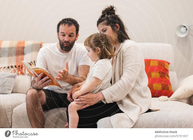 Märchenstunde mit der Familie auf einem gemütlichen Sofa lesen Buch Kind Eltern Bildung Lernen Bonden Geschichtenerzählen Mutter Vater Tochter heimwärts