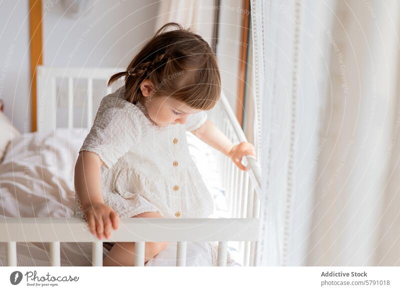 Kleinkind erkundet die Welt vom Kinderbett aus Babybett Neugier Erkundung Schlafzimmer Säugling Mädchen Kleid weiß Sicherheit Schiene im Innenbereich heimwärts