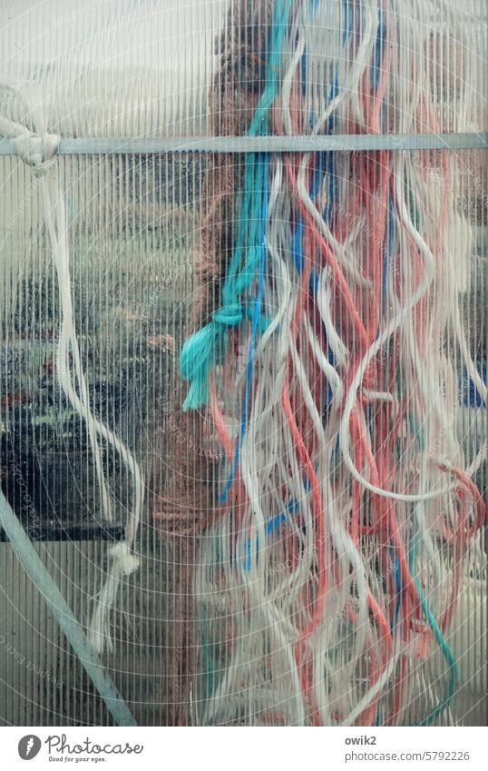 Sammelband Stricke mehrfarbig Sammelsurium Bänder hängend zusammen Vorrat Reste Kunststoff Seile weiß rot türkis durcheinander verworren Glaswand Strukturglas